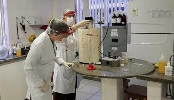 Pessoas fabricando álcool gel em laboratório da Ufes